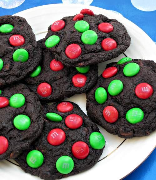 Čokoládové vianočné sušienky ozdobené červenými a zelenými lentilkami.