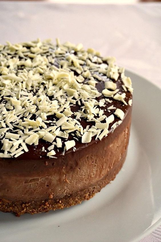 Čokoládová nepečená torta, plnená a posypaná čokoládou.