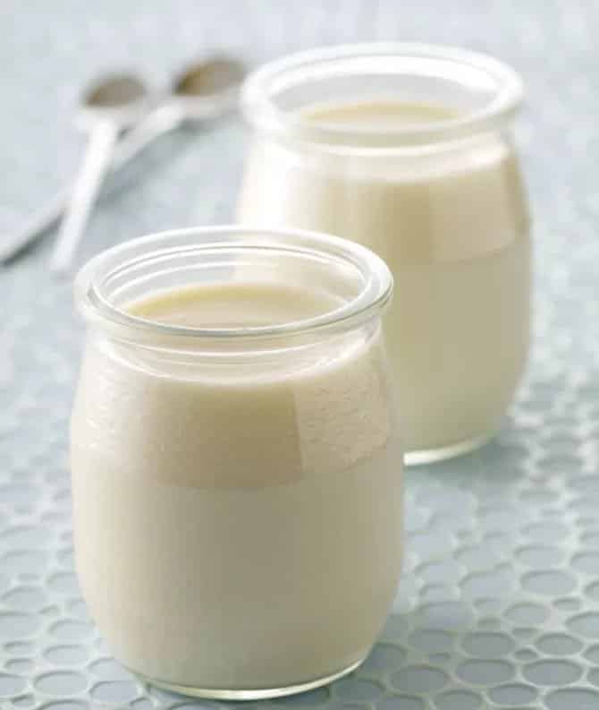 Biely jogurt z jogurtovača servírovaný v pohároch.