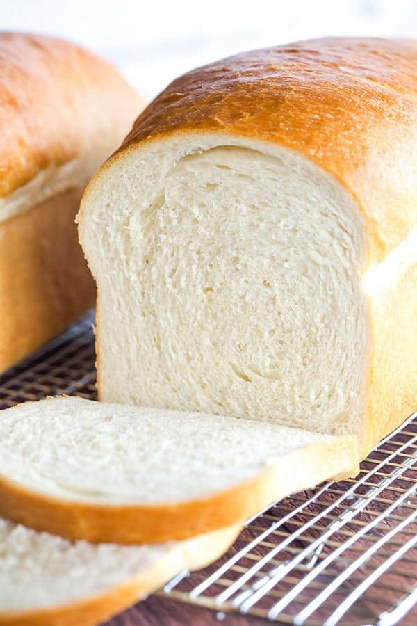 Biely chlieb, rozkrojený, servírovaný na mriežke.