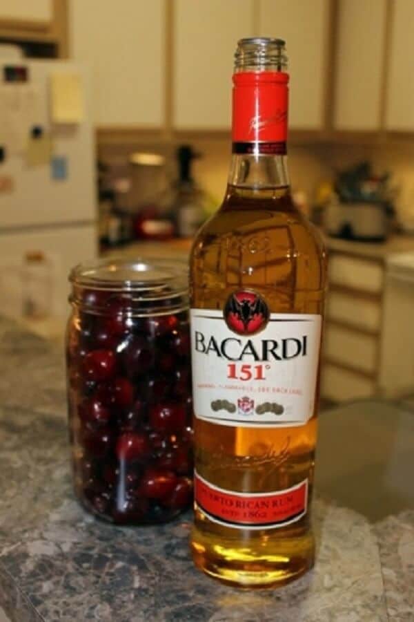 Poháre nakladaných čerešní a vedľa položená plná fľaša Bacardi.