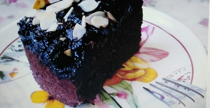 Kakaová torta posypaná mandľami servírovaná na tanieri.