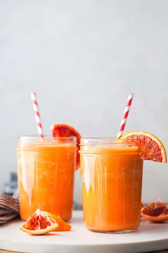 Lahodný zdravý nápoj z jabĺk a mrkvy ozdobený pomarančom.