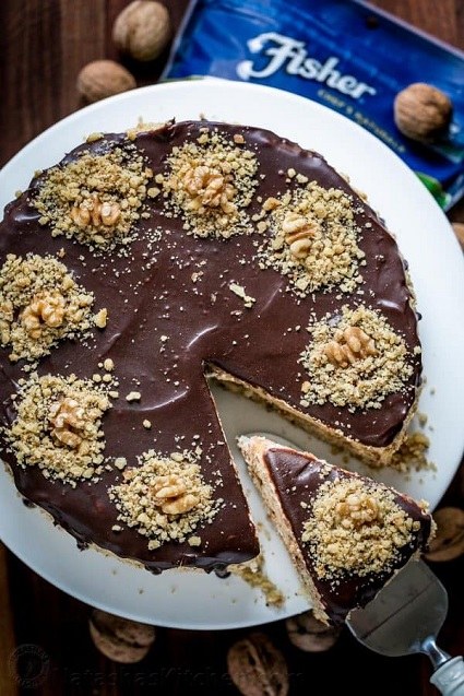 Orechový pečený koláč, zdobený čokoládovou polevou.