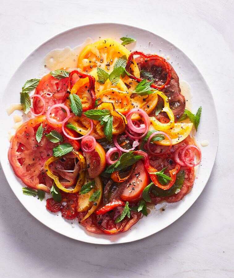 Šalát z paradajok, paprík, cibule a mäty servírovaný na tanieri.