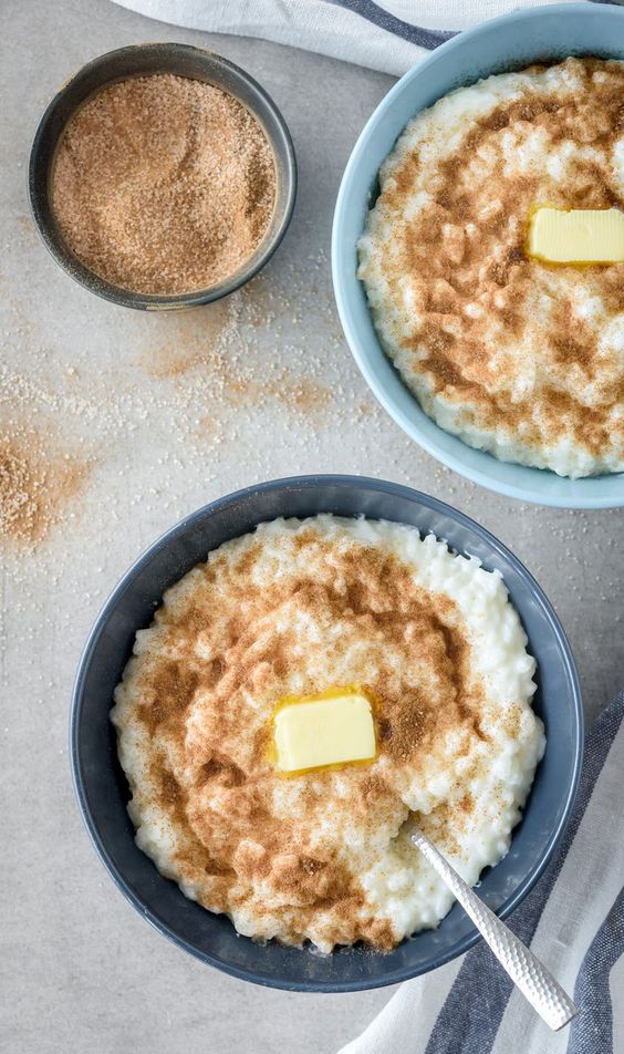 Dve misky plné uvarenej ryže so škoricovým cukrom a maslom.