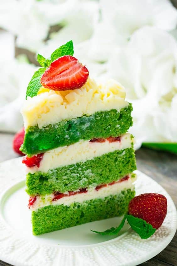 Kus zelenej torty s vanilkovým krémom a dochutený jahodami.