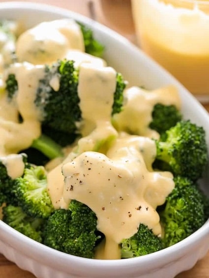 Uvarená brokolica preliata omáčkou zo syra s muškátovým orieškom.