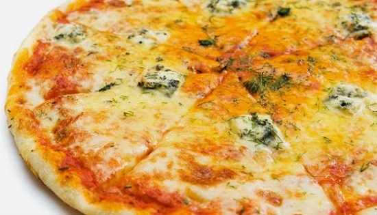 Syrová pizza quattro formaggi posypaná čerstvým kôprom.