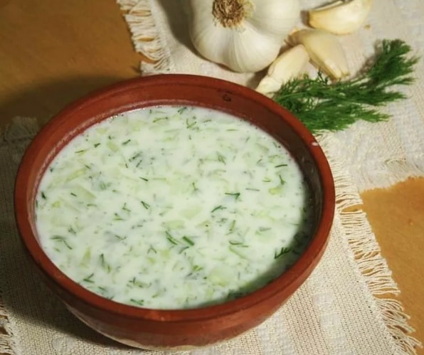 Studená polievka tarator z uhorky v hnedej miske.