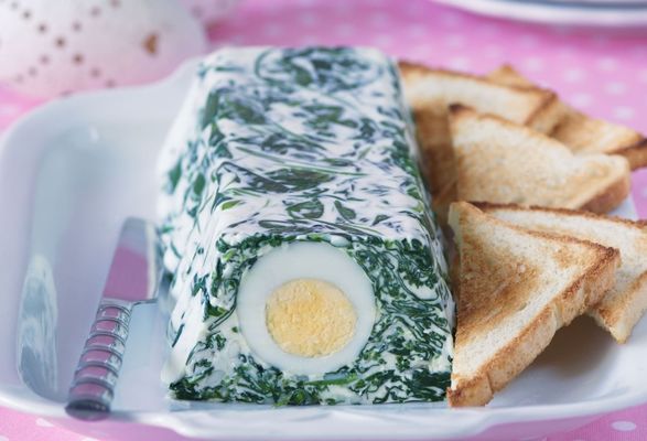 Vajíčková tlačenka so špenátom a syrom cottage servírovaná na tanieriku s opečenými plátkami toastového chleba.