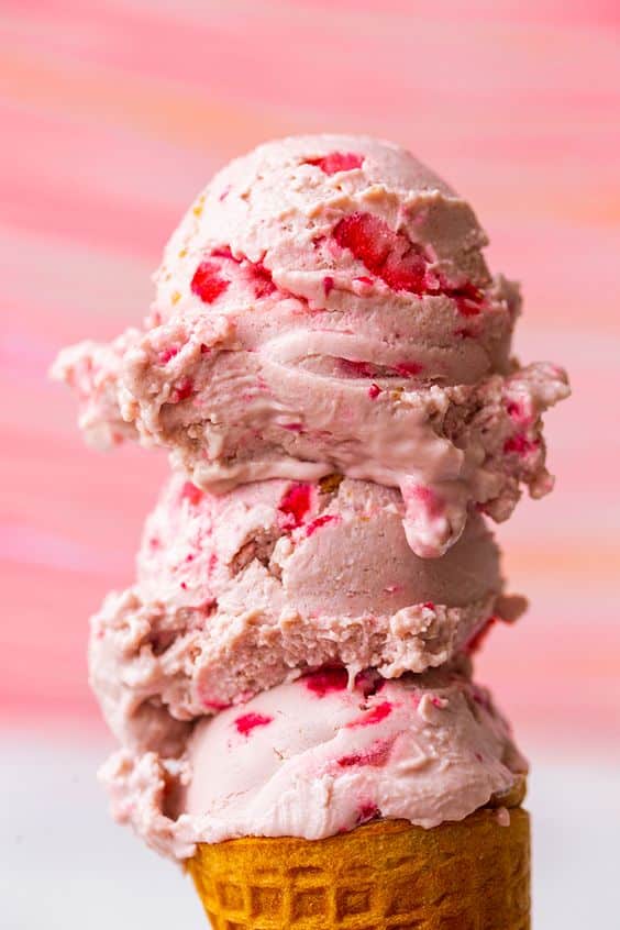 Kornút naplnený tromi kopčekmi ružovej zmrzliny.