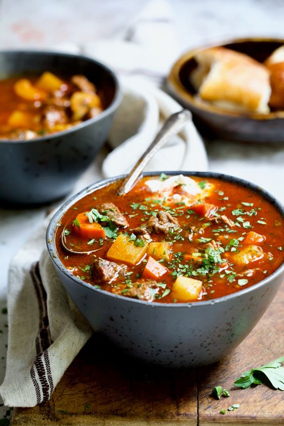Miska plná lahodnej polievky so zemiakmi, mäsom a slaninou.