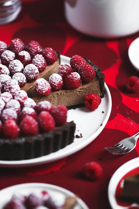 Nádherný čokoládový koláč s celými malinami a práškovým cukrom.