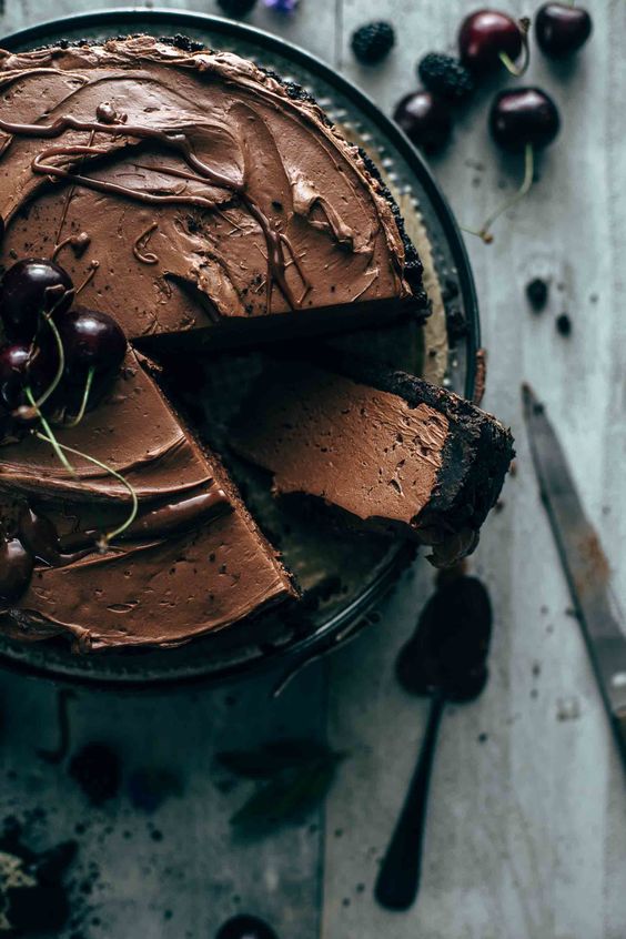 Celý koláč plný lahodnej krémovej čokoládovej náplne ozdobený višňami.